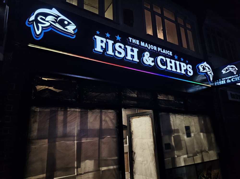Fish and chips shopfront sign at night