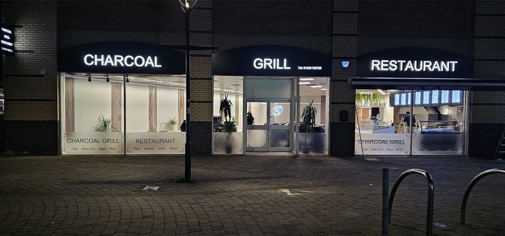 Restaurant shopfront and window signage at night