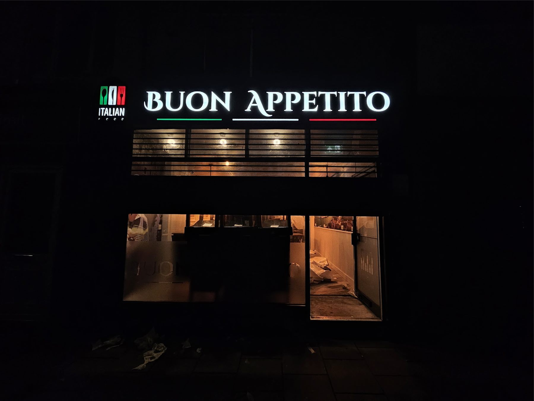 Illuminated shopfront sign at night
